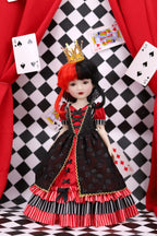 Doll in a red, black, and white outfit with a crown against a checkered background