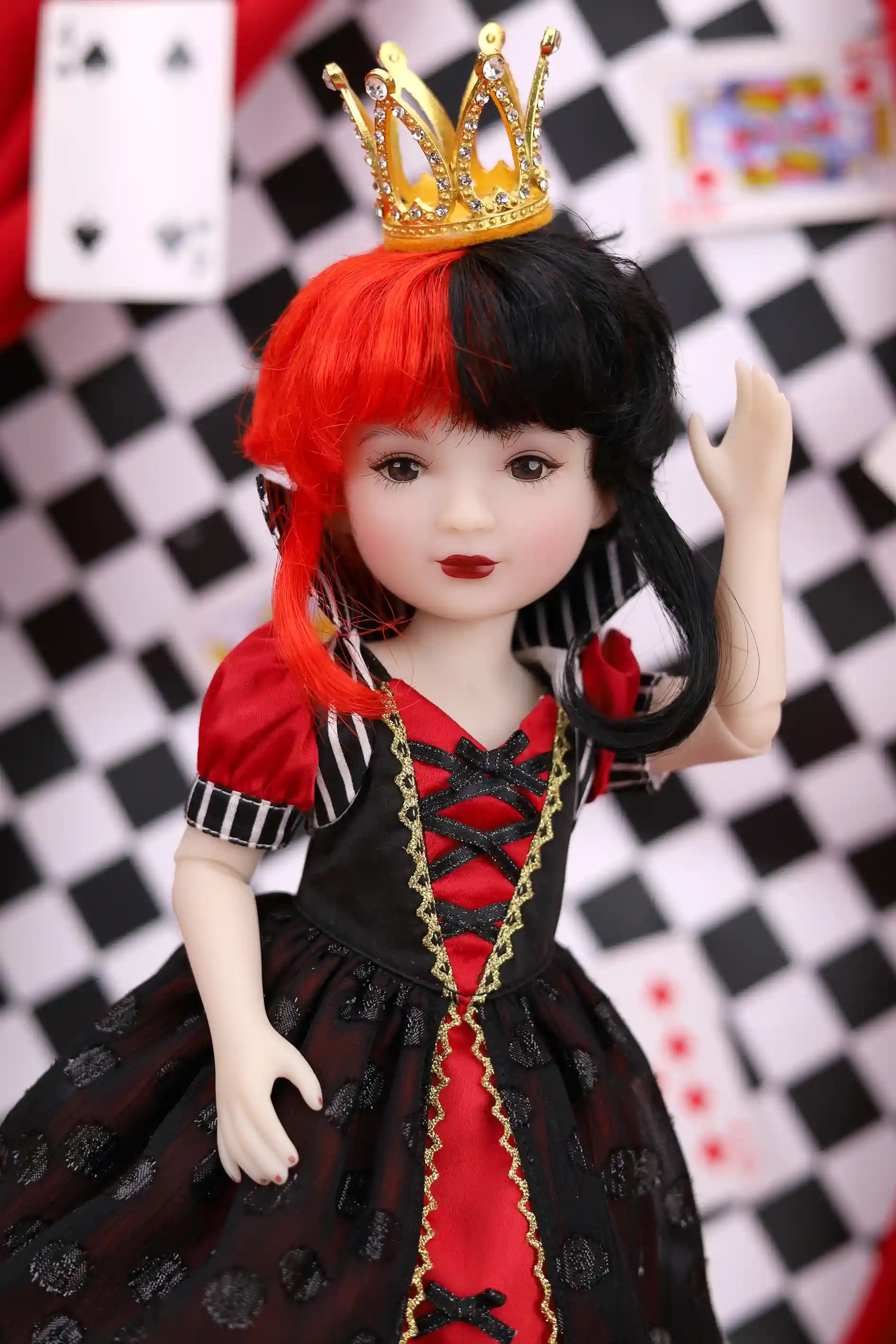 Doll with red and black outfit and gold crown against a checkered background