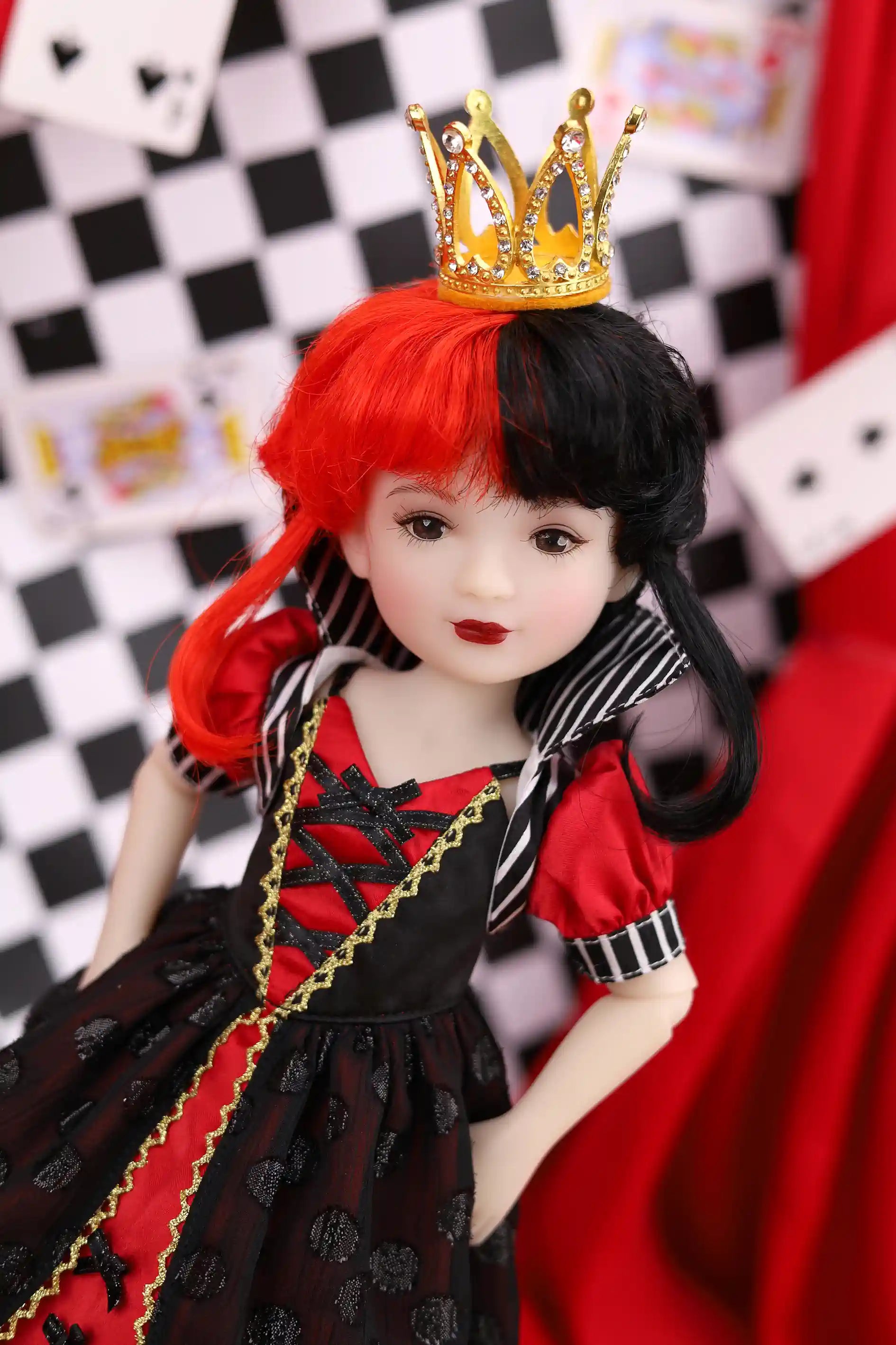 Doll with red and black hair, gold crown, and black and red outfit against a checkered and red background.