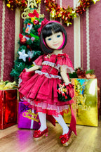 Doll in a red dress with a Christmas tree and presents in the background