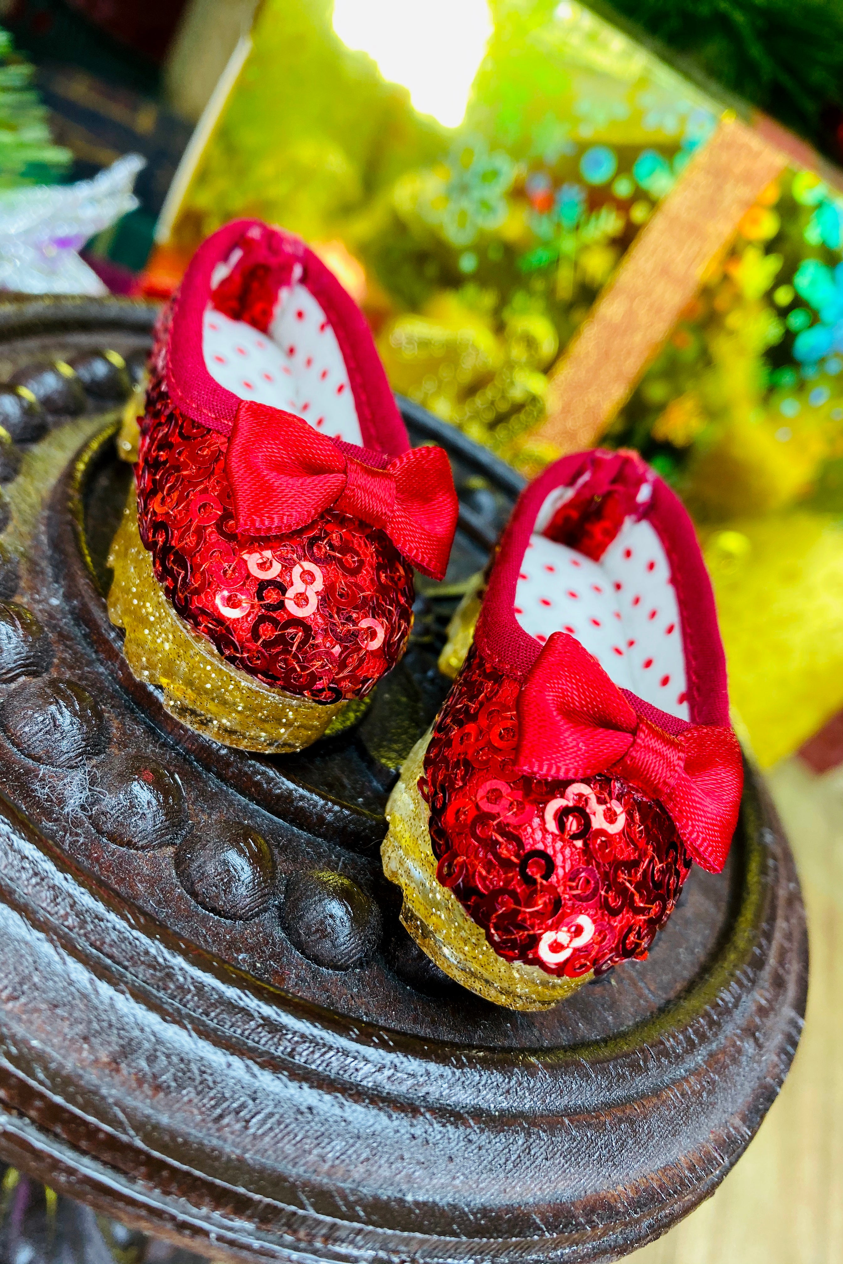 Red sequin shoes with bows on a decorative stand