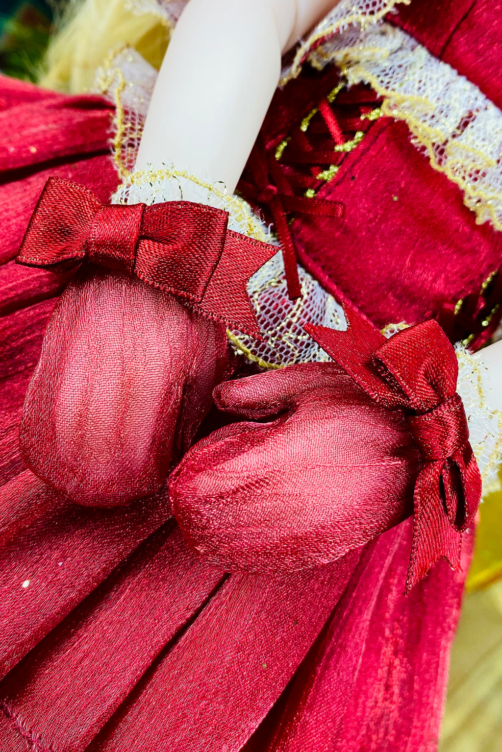Close-up of a red fabric heart with a bow, part of a larger decorative item.