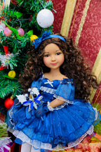  Doll in a blue dress with a Christmas tree in the background