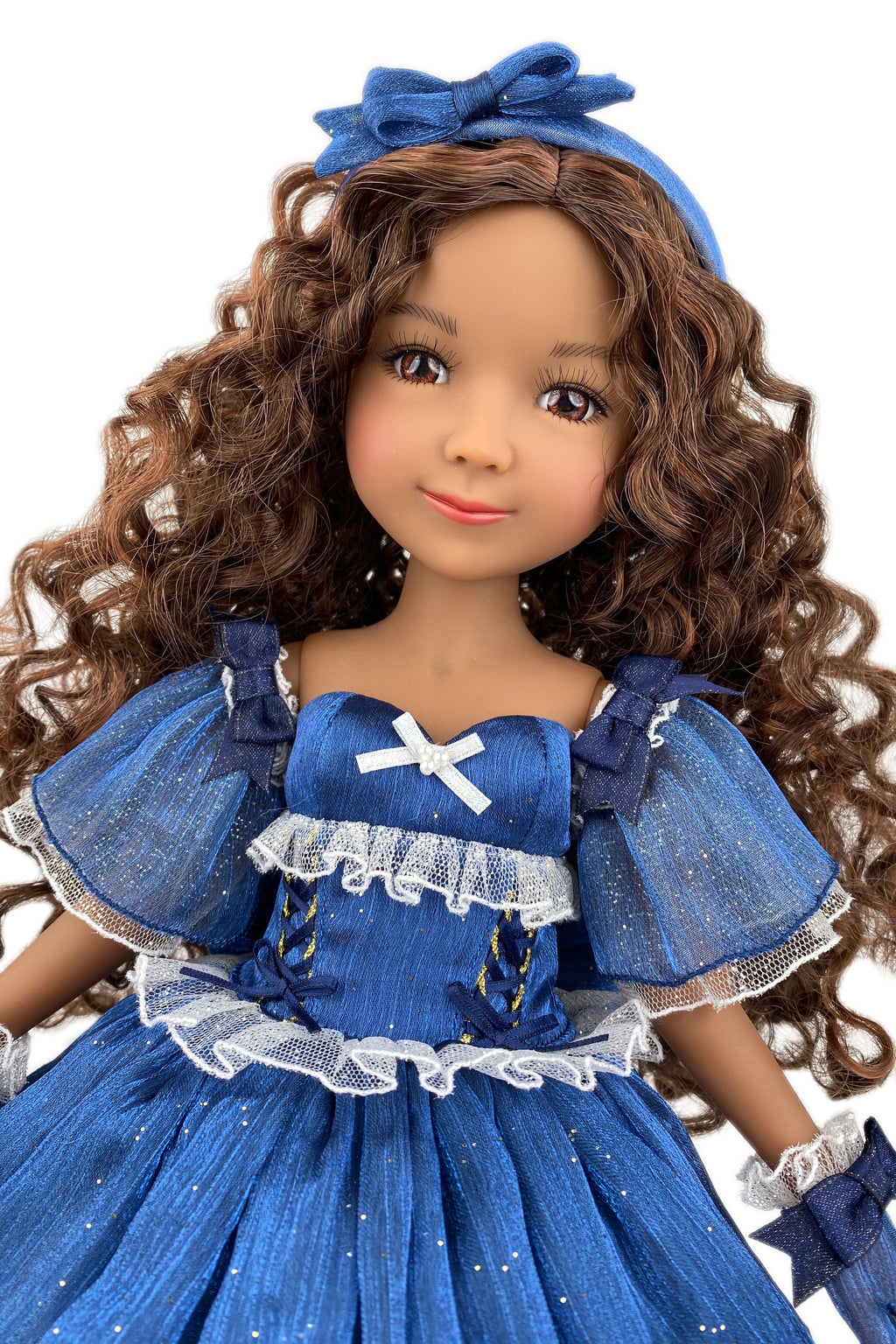 Doll in a blue dress with a bow headband on a white background