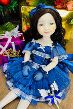 Doll in a blue dress with decorative elements on a textured surface
