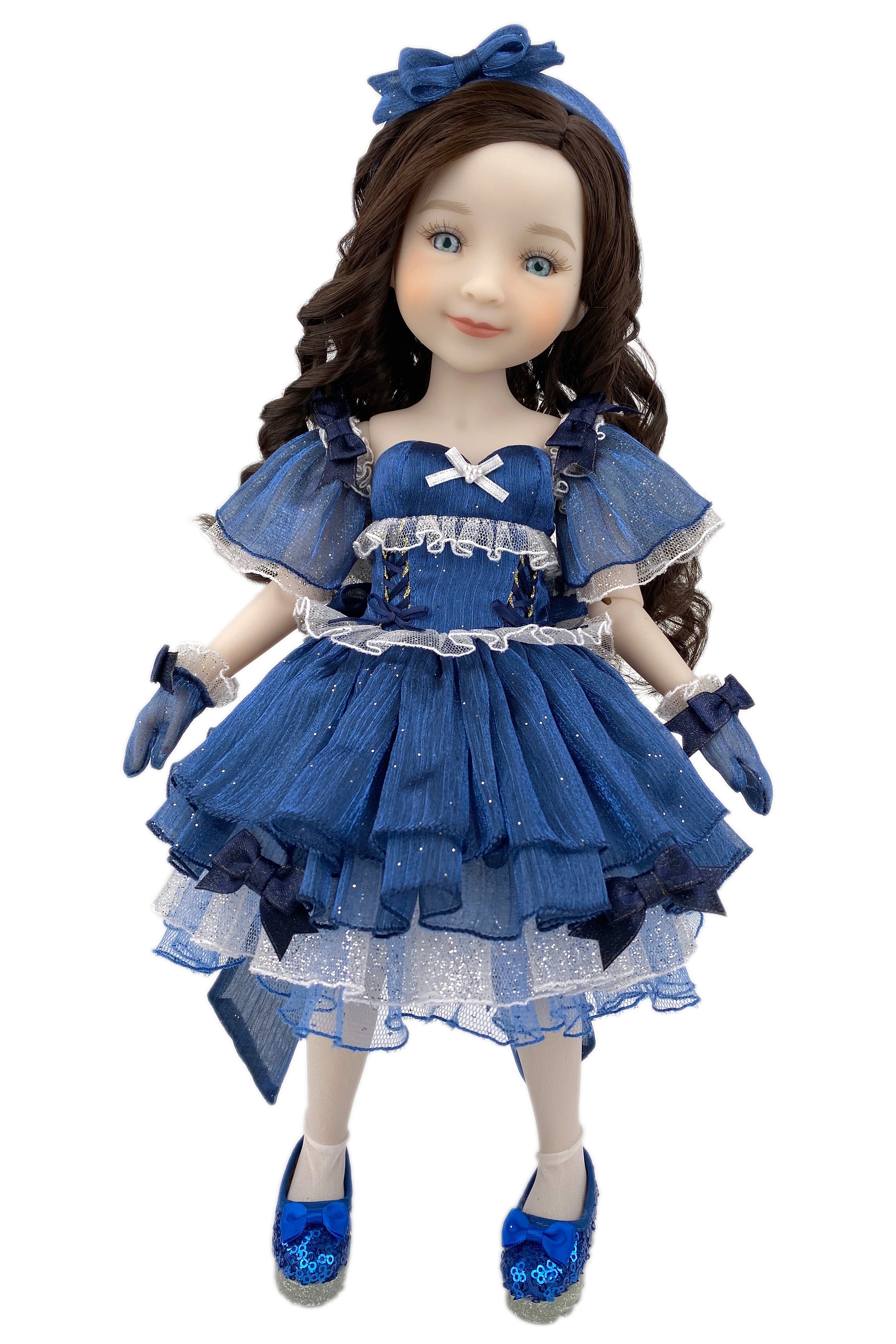 Doll wearing a blue dress with ruffles and a matching headband on a white background