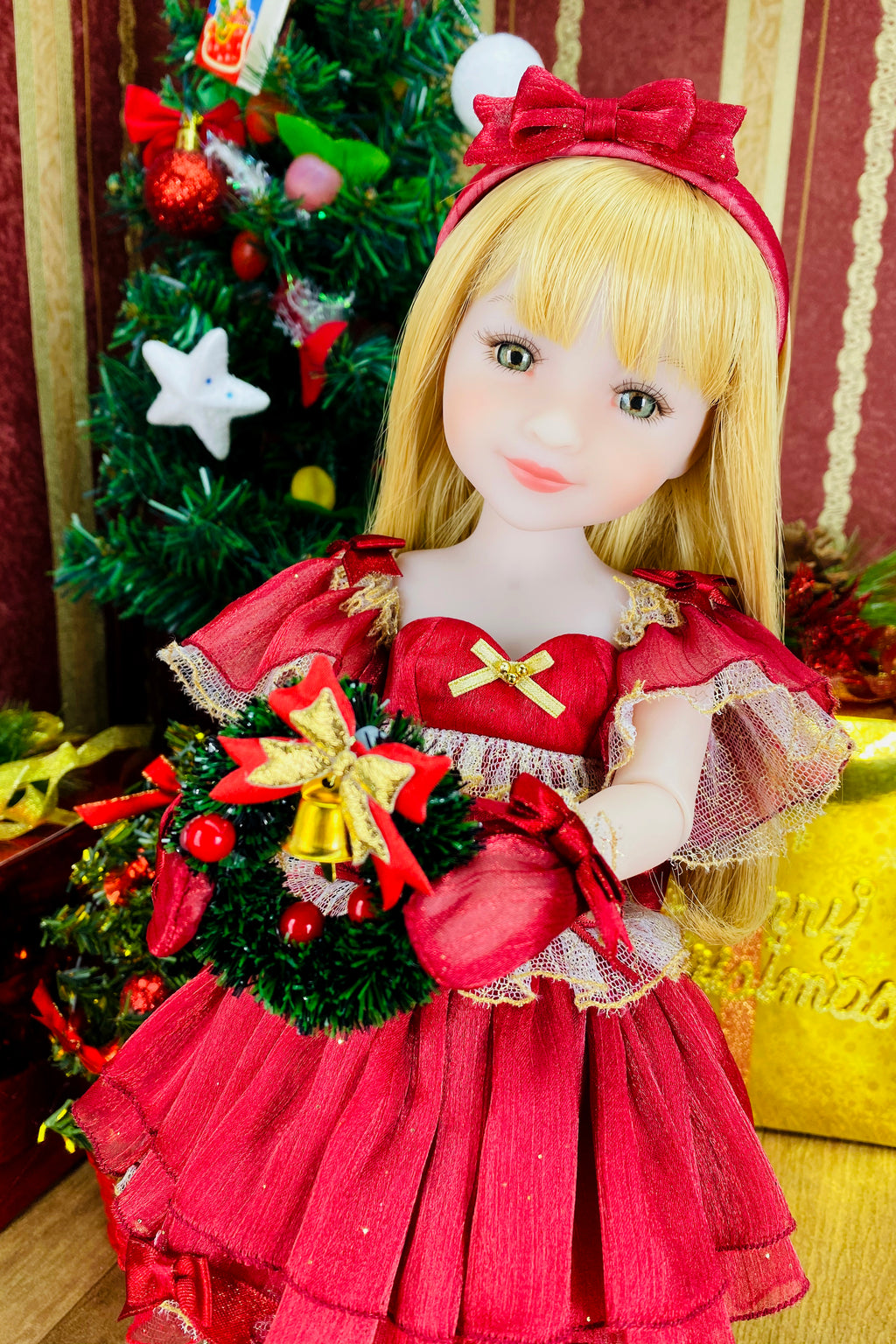 Doll in a red dress with a Christmas tree in the background