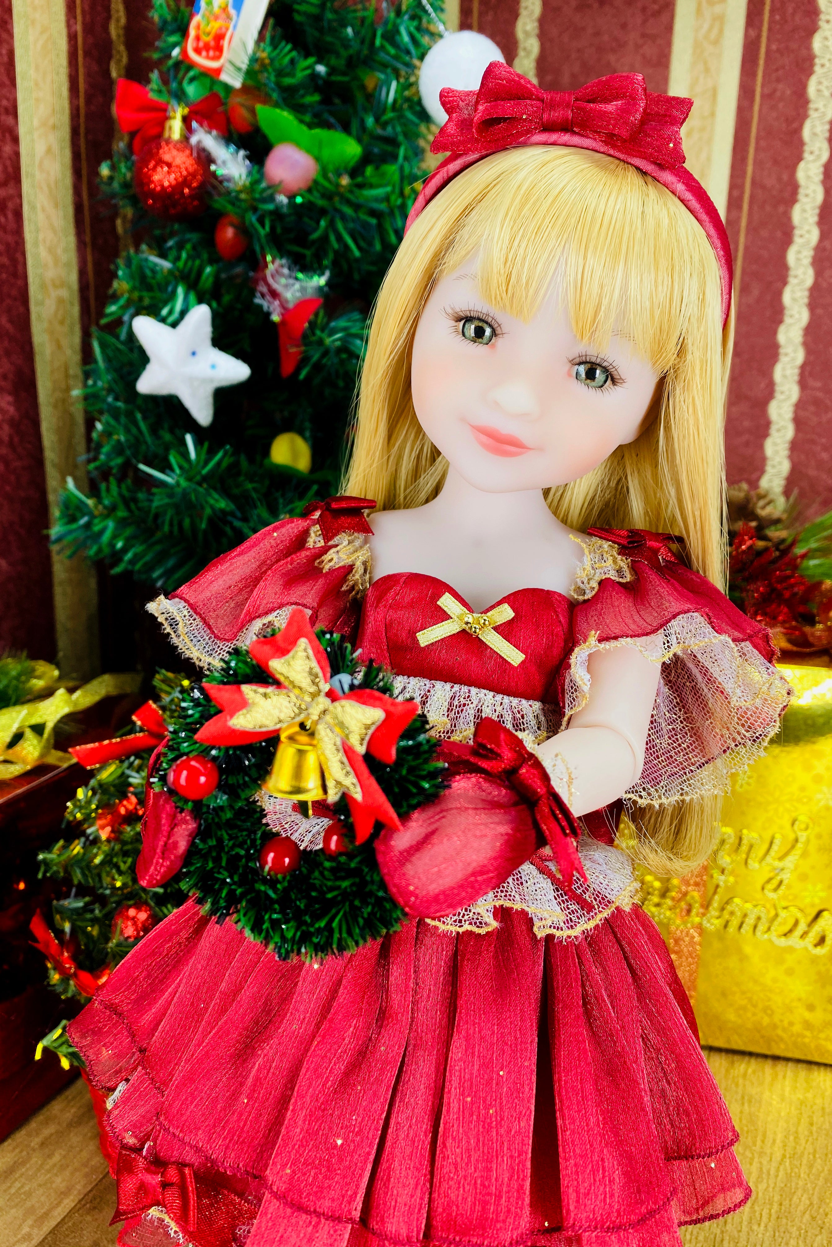 Doll in a red dress with a Christmas tree in the background