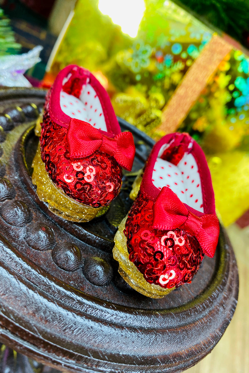 Red sequin shoes with bows on a decorative stand