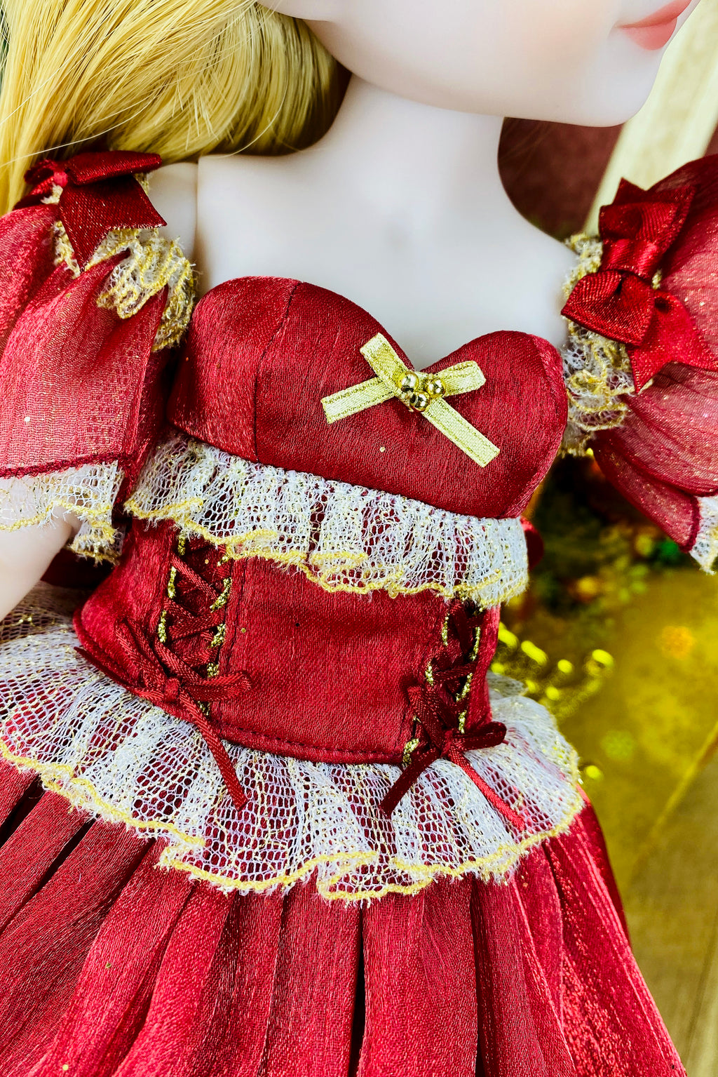 Close-up of a doll wearing a red dress with gold accents