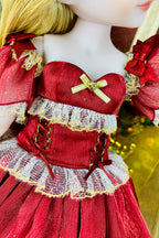 Close-up of a doll wearing a red dress with gold accents