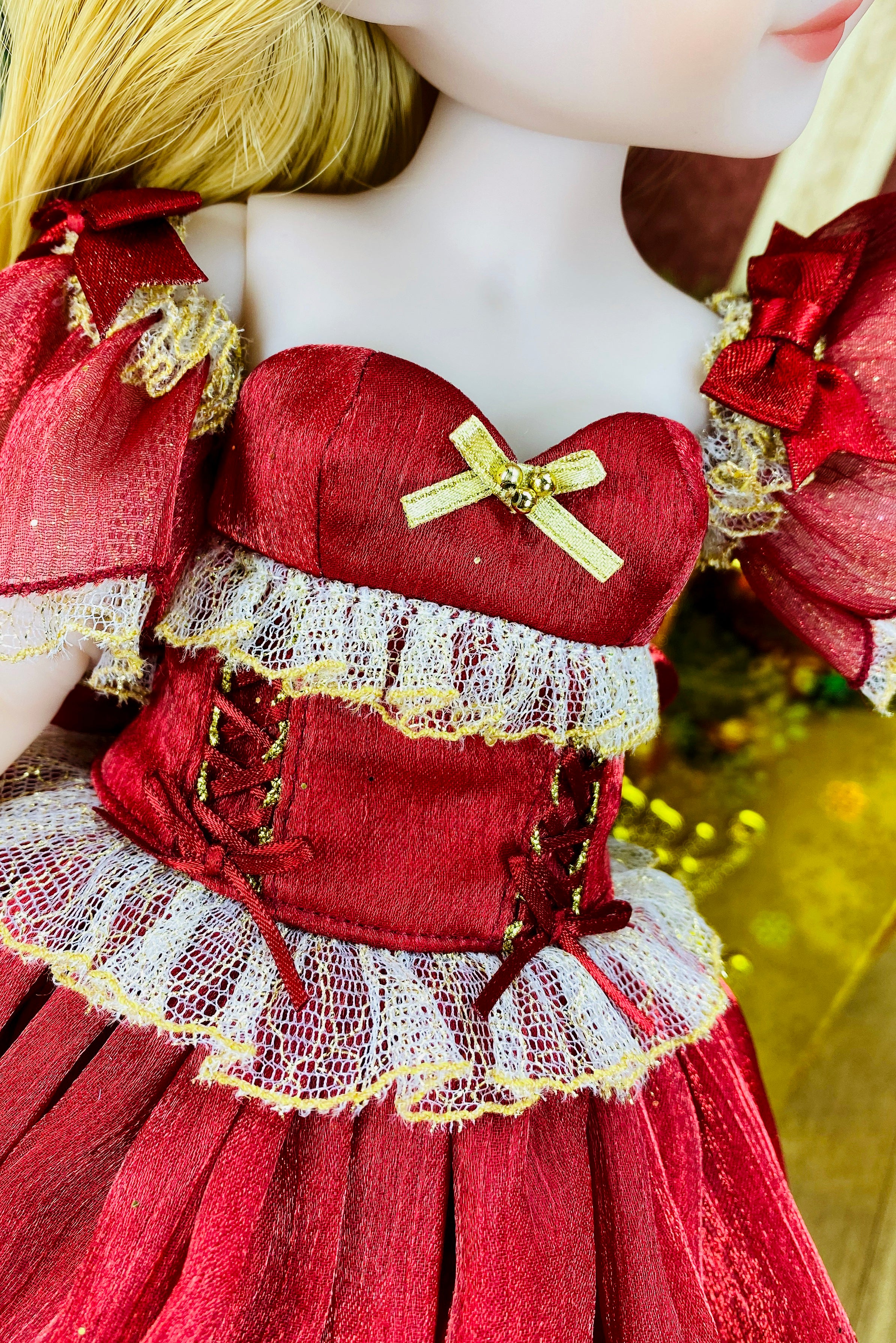 Close-up of a doll wearing a red dress with gold accents