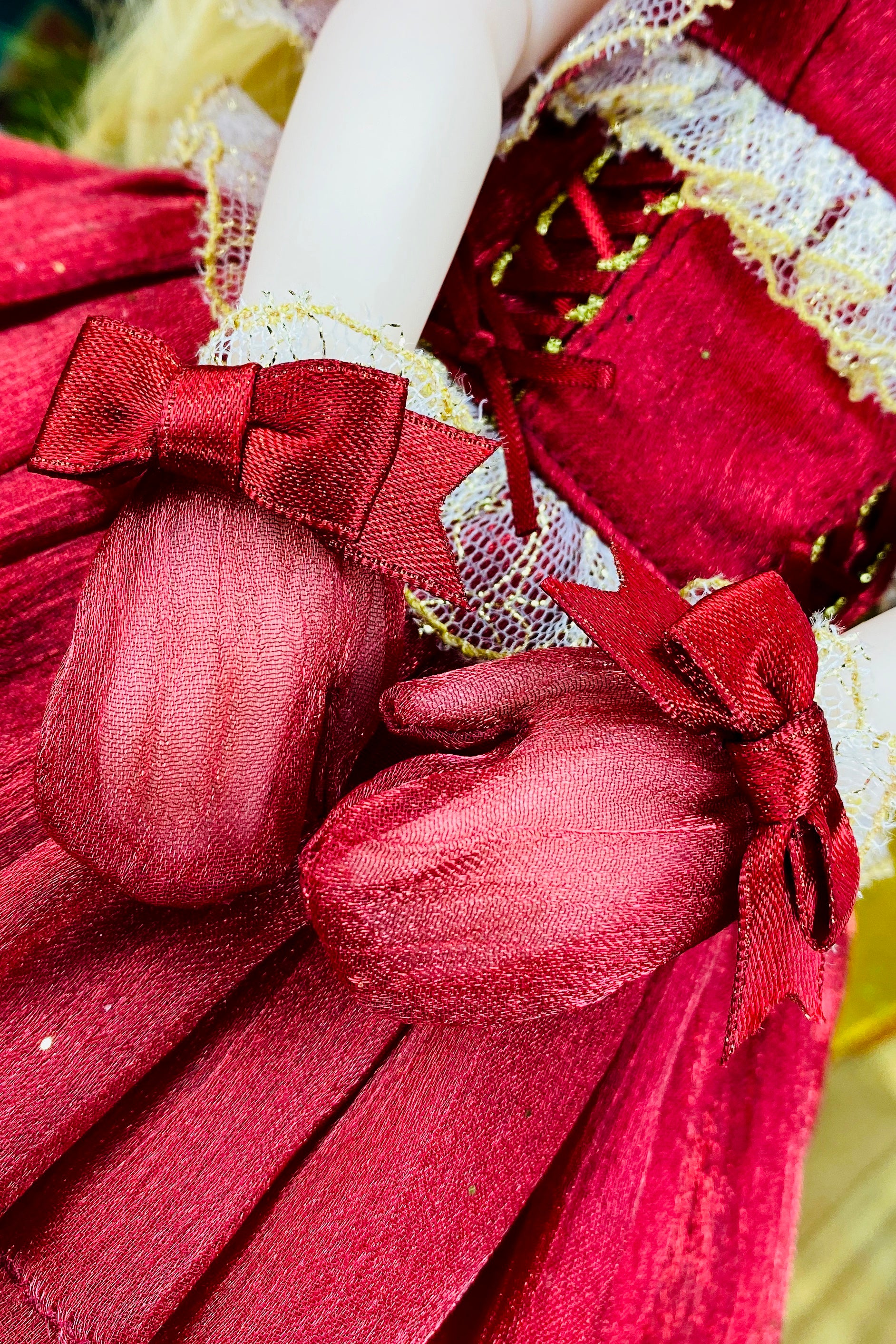 Close-up of a red fabric heart with a bow, part of a larger decorative item.