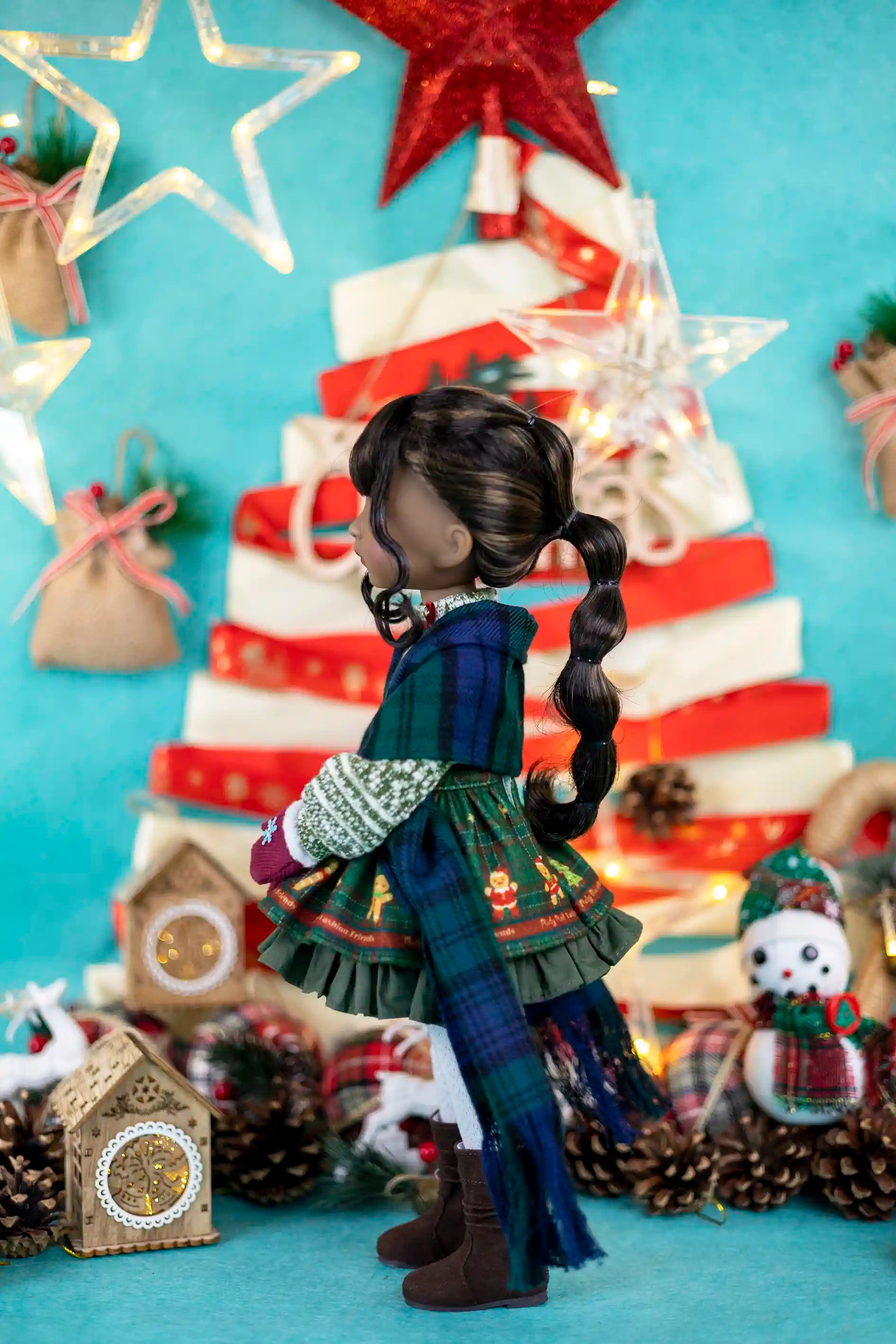 Doll in festive outfit with Christmas tree and decorations on a blue background