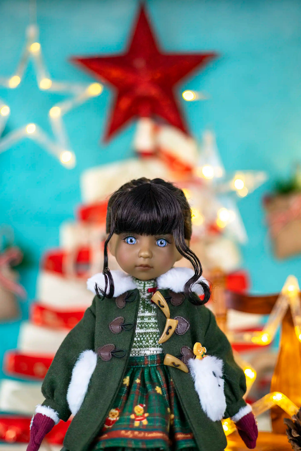 Doll in a festive outfit with a Christmas tree and star in the background