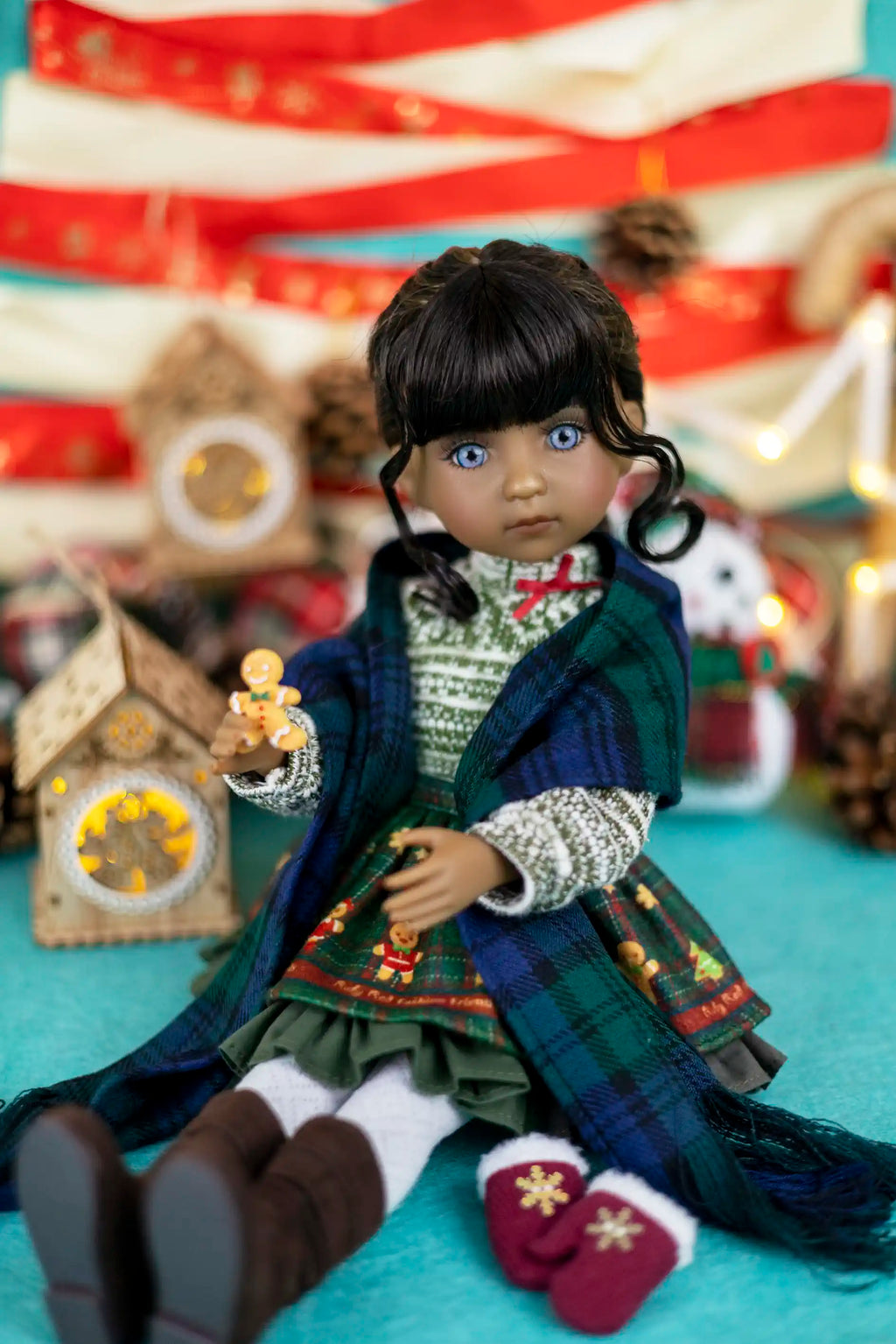 Doll in a festive outfit with a Christmas tree and star in the background