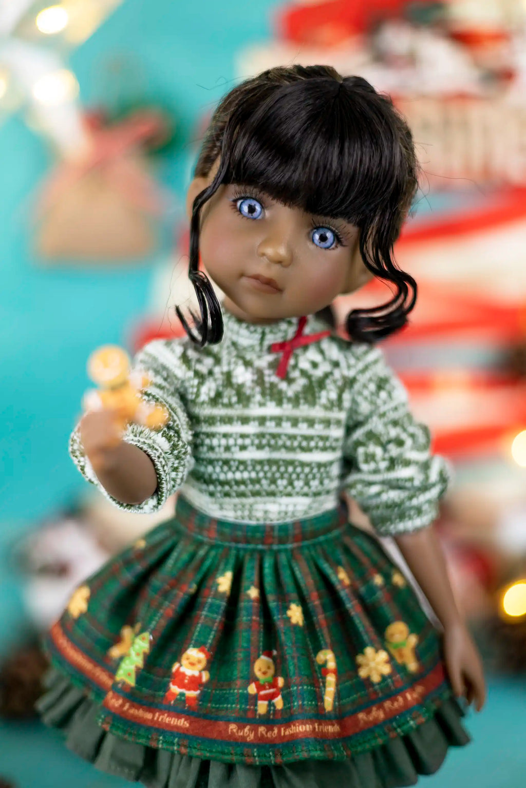 Doll wearing a green dress with a pattern, standing against a blurred background.
