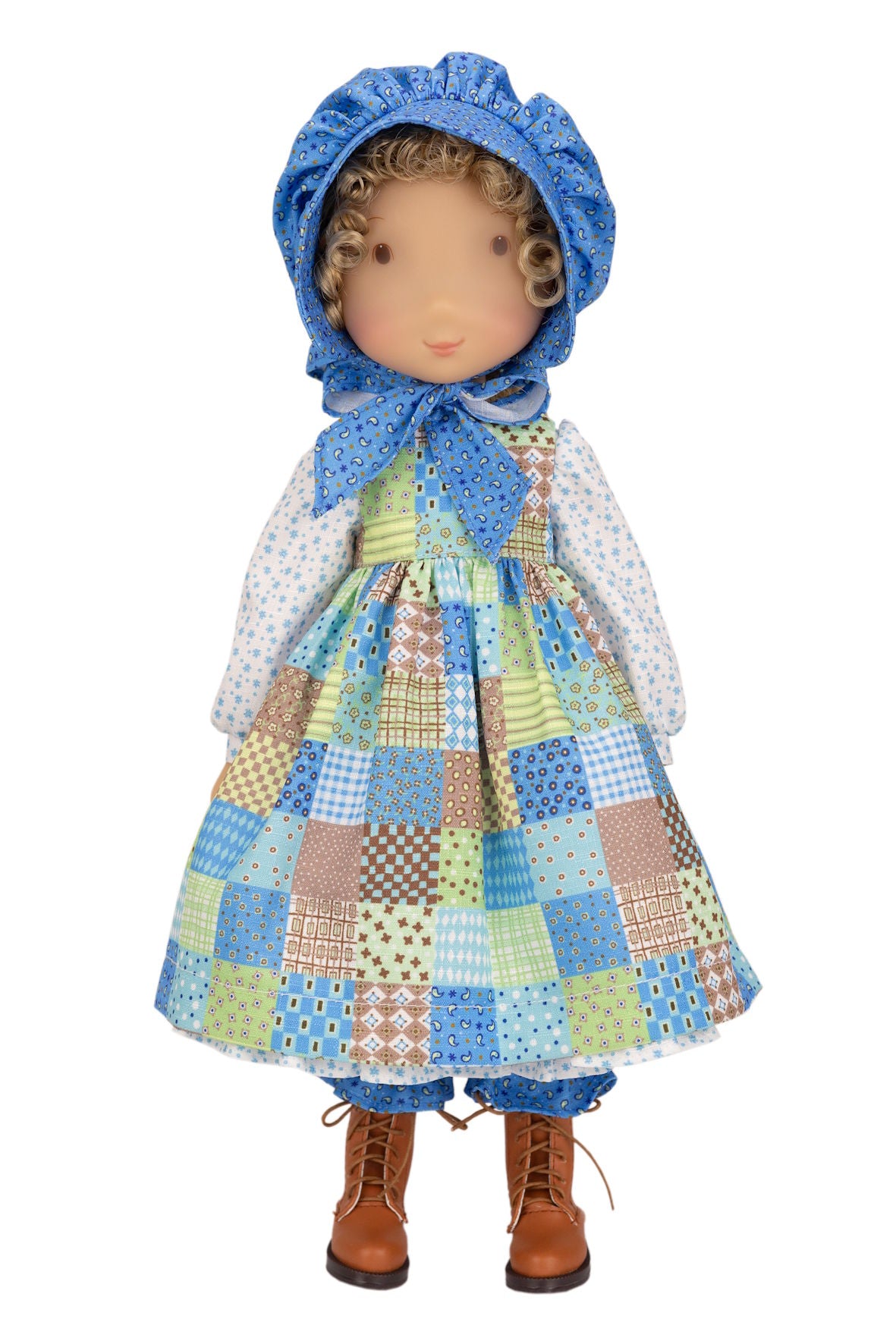Holly Hobbie Doll wearing a patchwork dress and blue bonnet on a white background