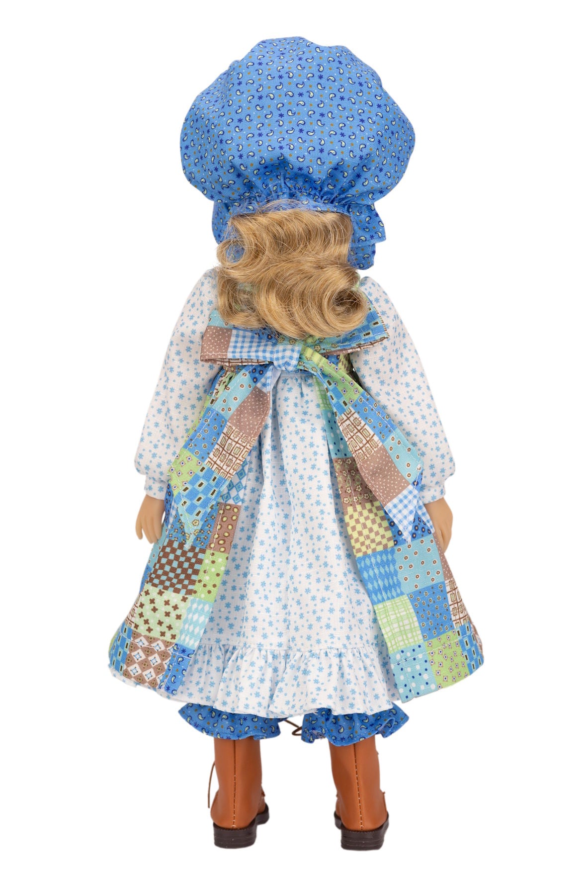 Holly Hobbie Doll wearing a blue bonnet and patchwork dress on a white background