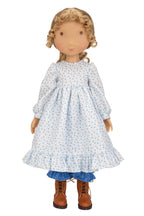 Holly Hobbie Doll wearing a blue floral dress with brown boots on a white background