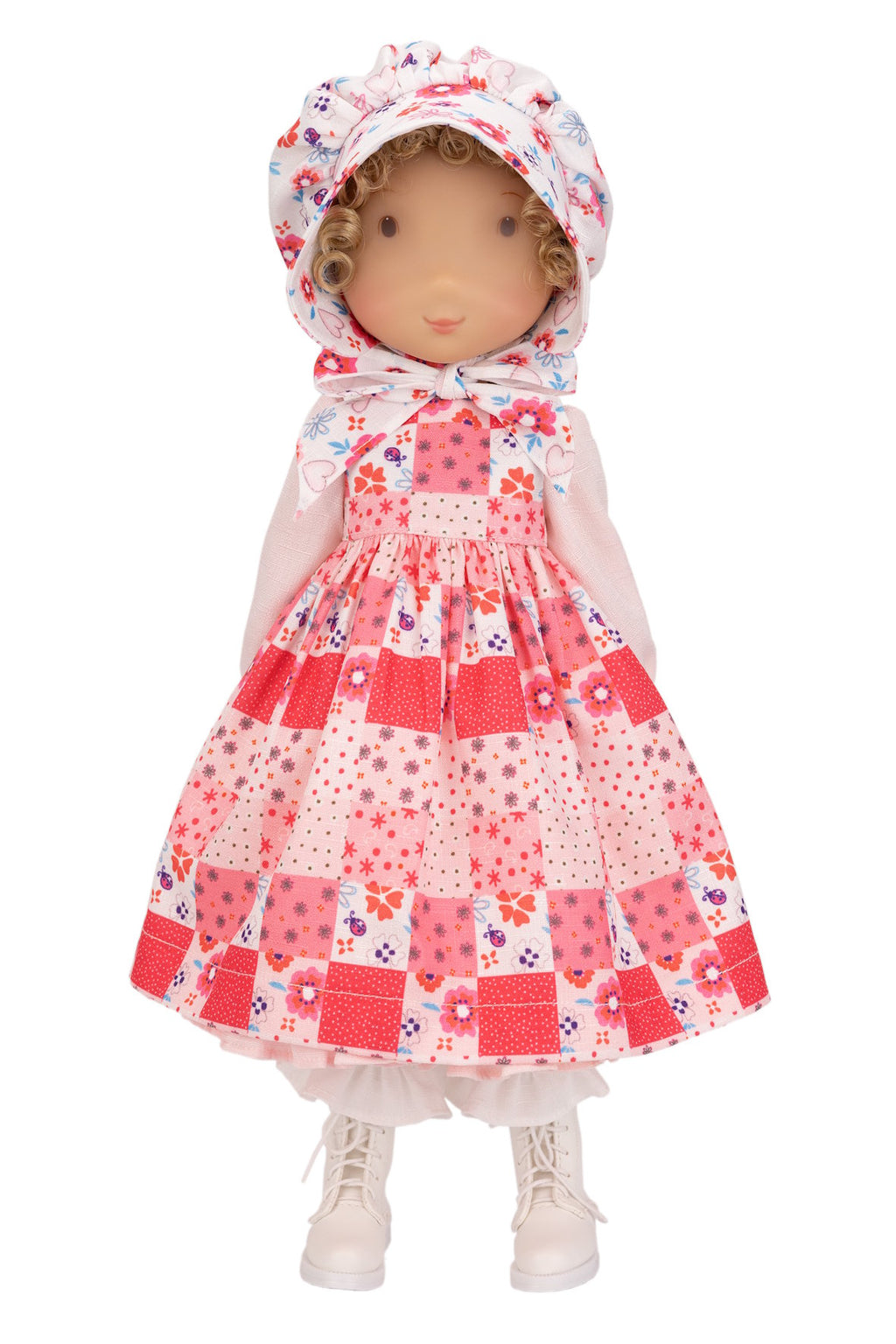 Holly Hobbie Doll wearing a patchwork dress with a floral hood on a white background