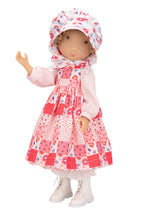 Holly Hobbie Doll wearing a floral dress and hat on a white background