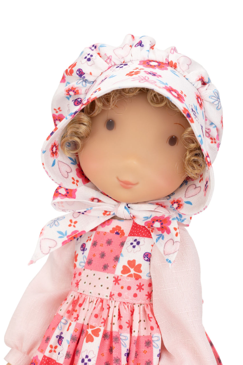 Holly Hobbie Doll wearing a floral dress and bonnet on a white background