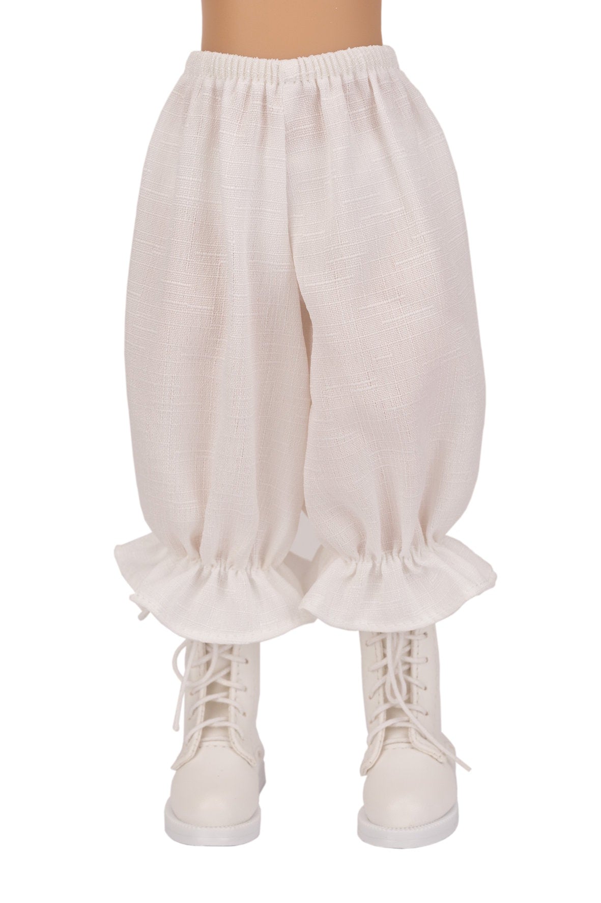 White ruffled pants worn with white sneakers on a white background