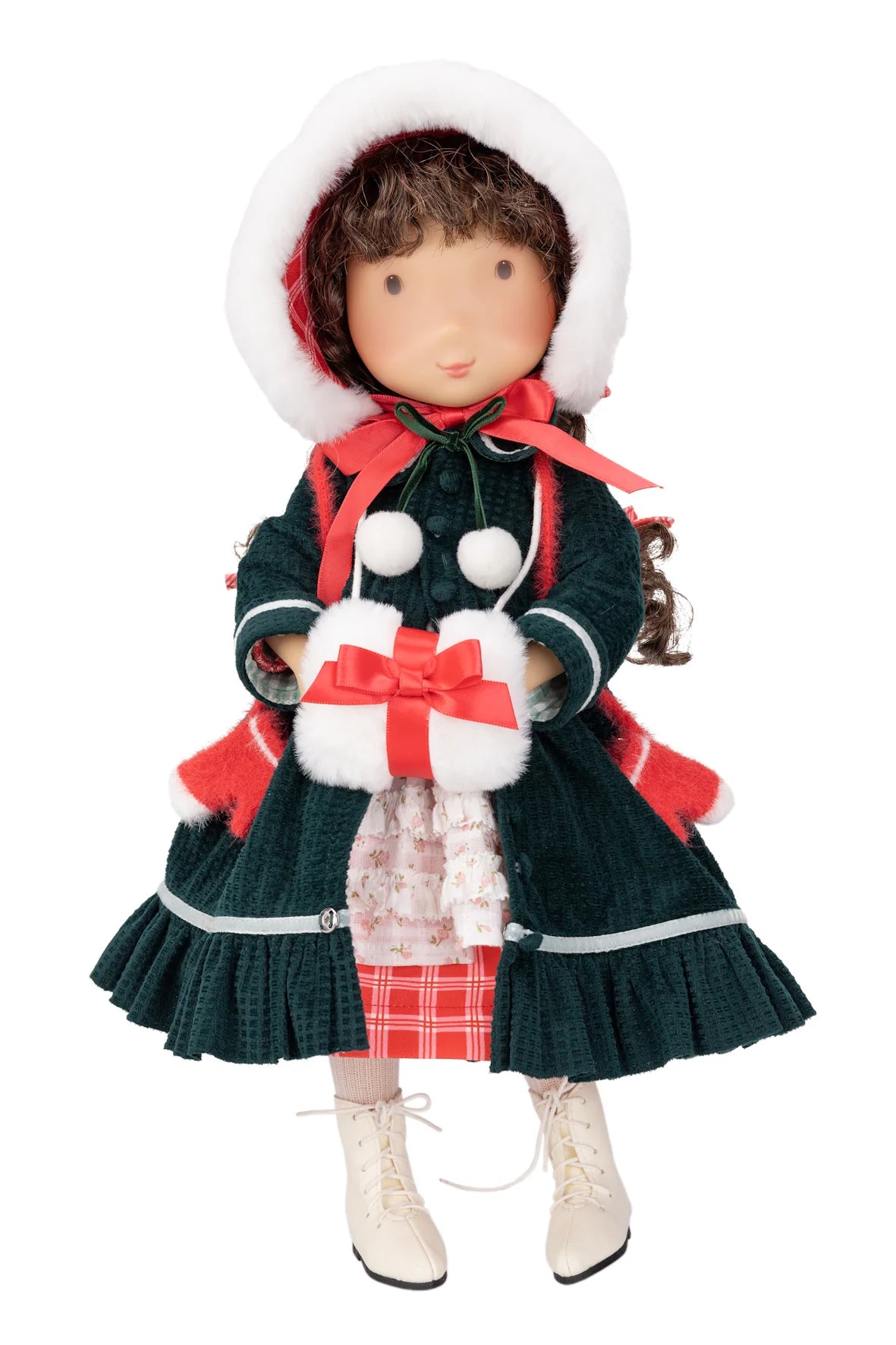 A Holly Hobbie Christmas doll dressed in a dark green textured coat with red and white accents, a white fur-trimmed bonnet, and cream-colored boots, holding a small wrapped gift against a plain white background.
