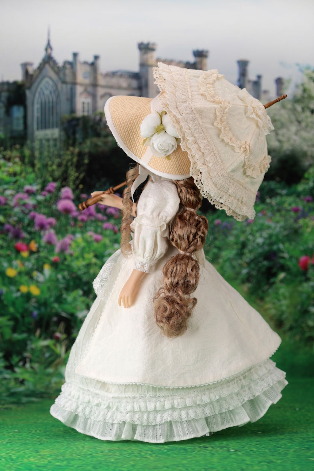 Vintage-style doll with a large hat and white dress in a garden setting