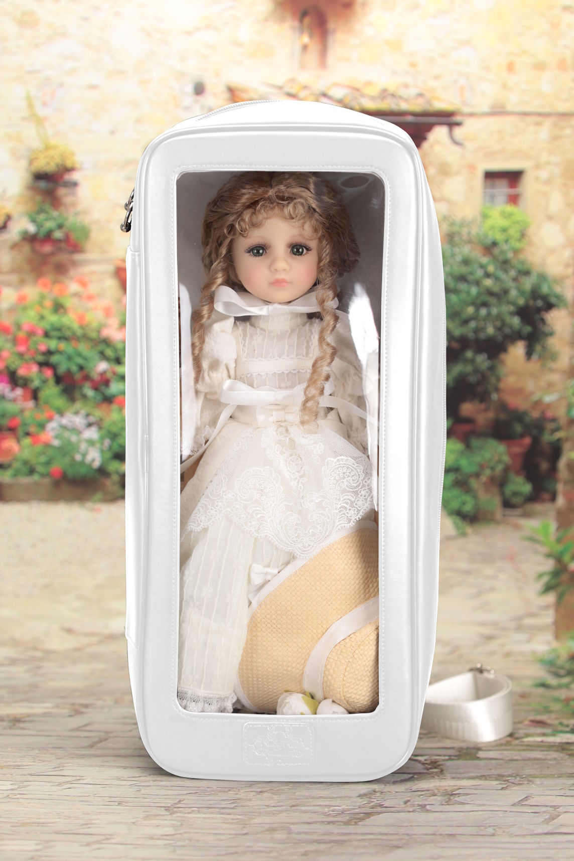 Doll in a white dress inside a white box with a garden background