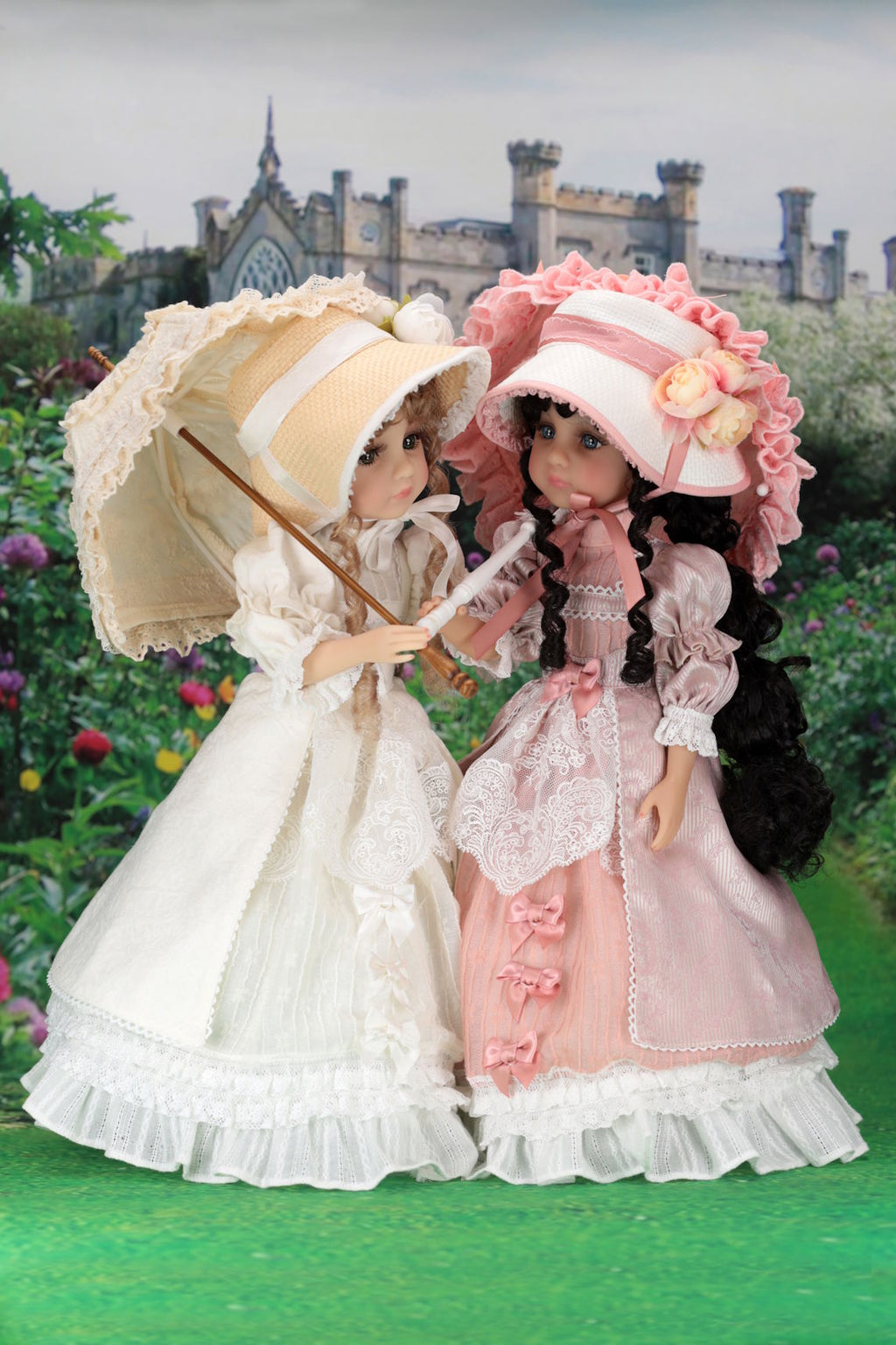 Two dolls in vintage dresses with parasols standing in a garden with a castle in the background.