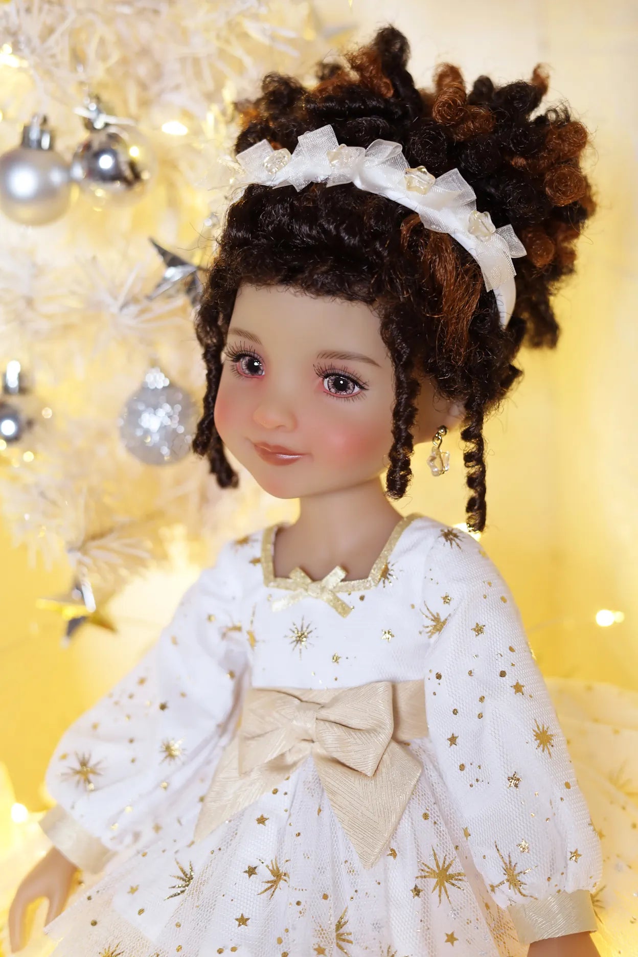 Doll in a white dress with gold accents against a blurred decorative background