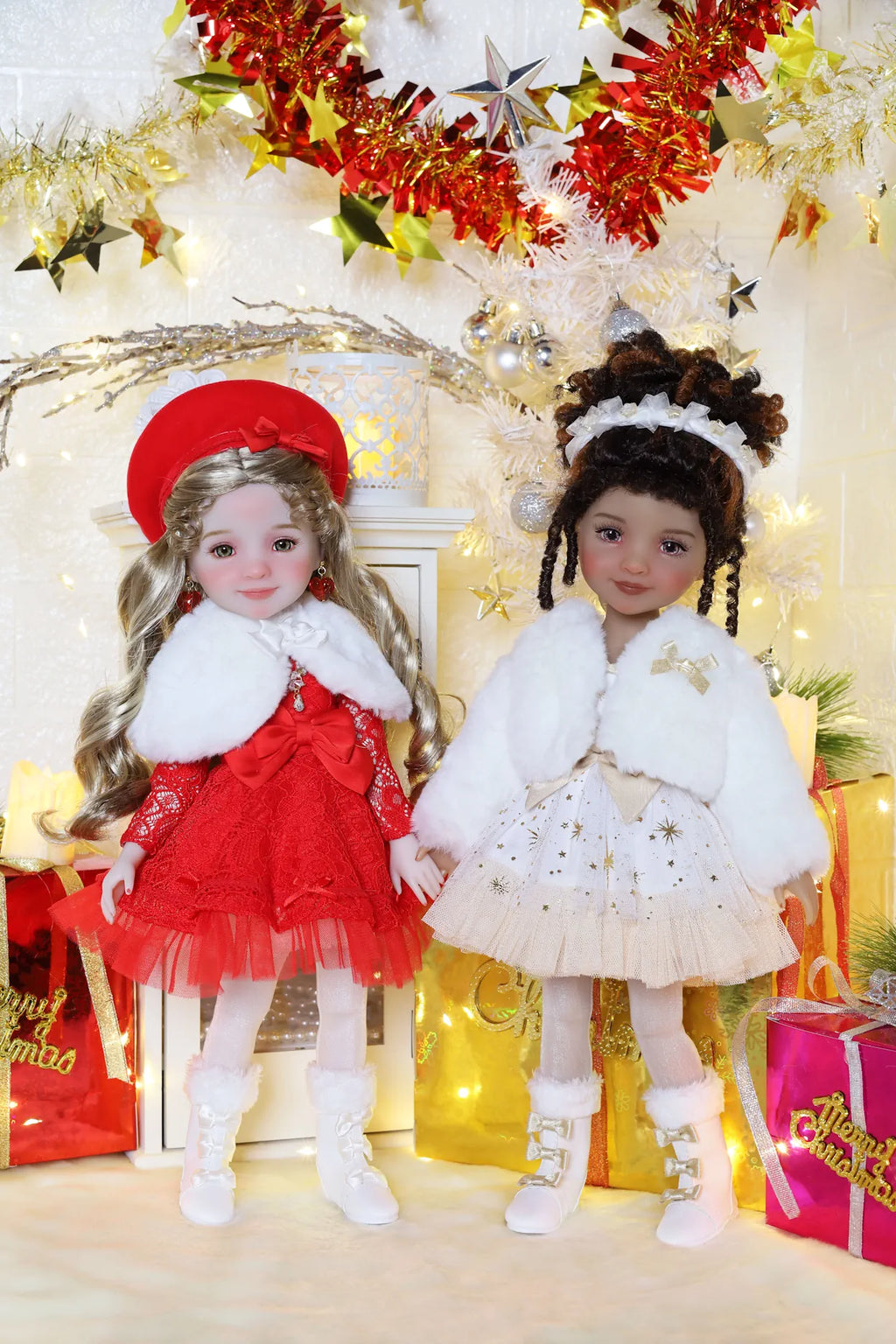 Two dolls in festive outfits standing in front of a decorated Christmas tree with lights and ornaments.