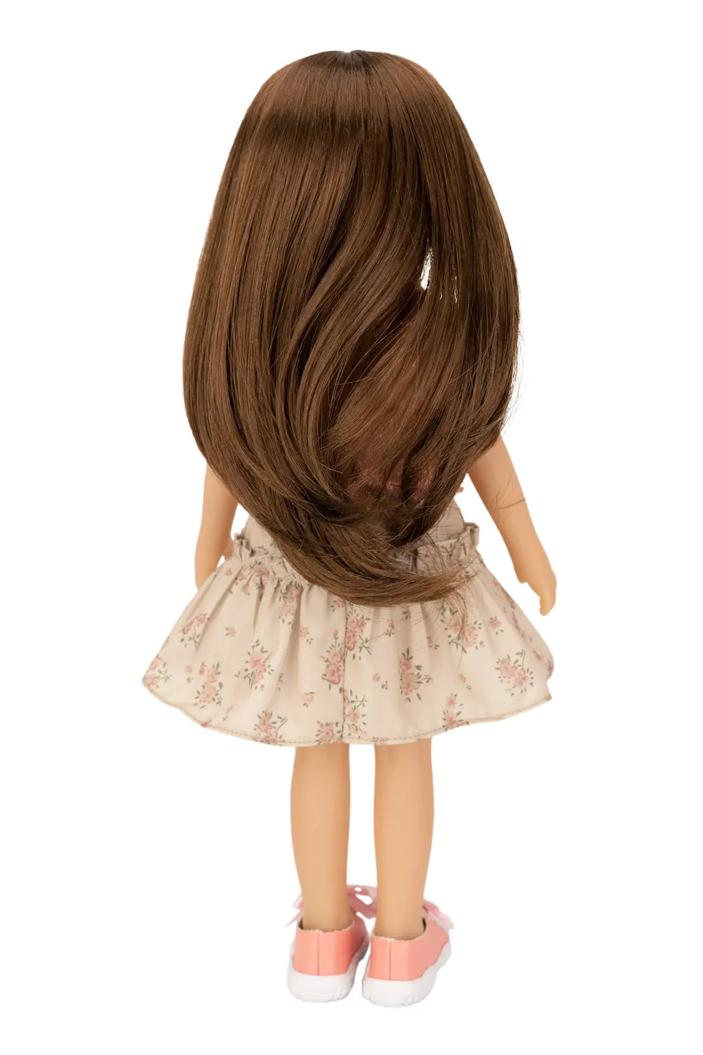 Doll with long brown hair and a floral skirt on a white background
