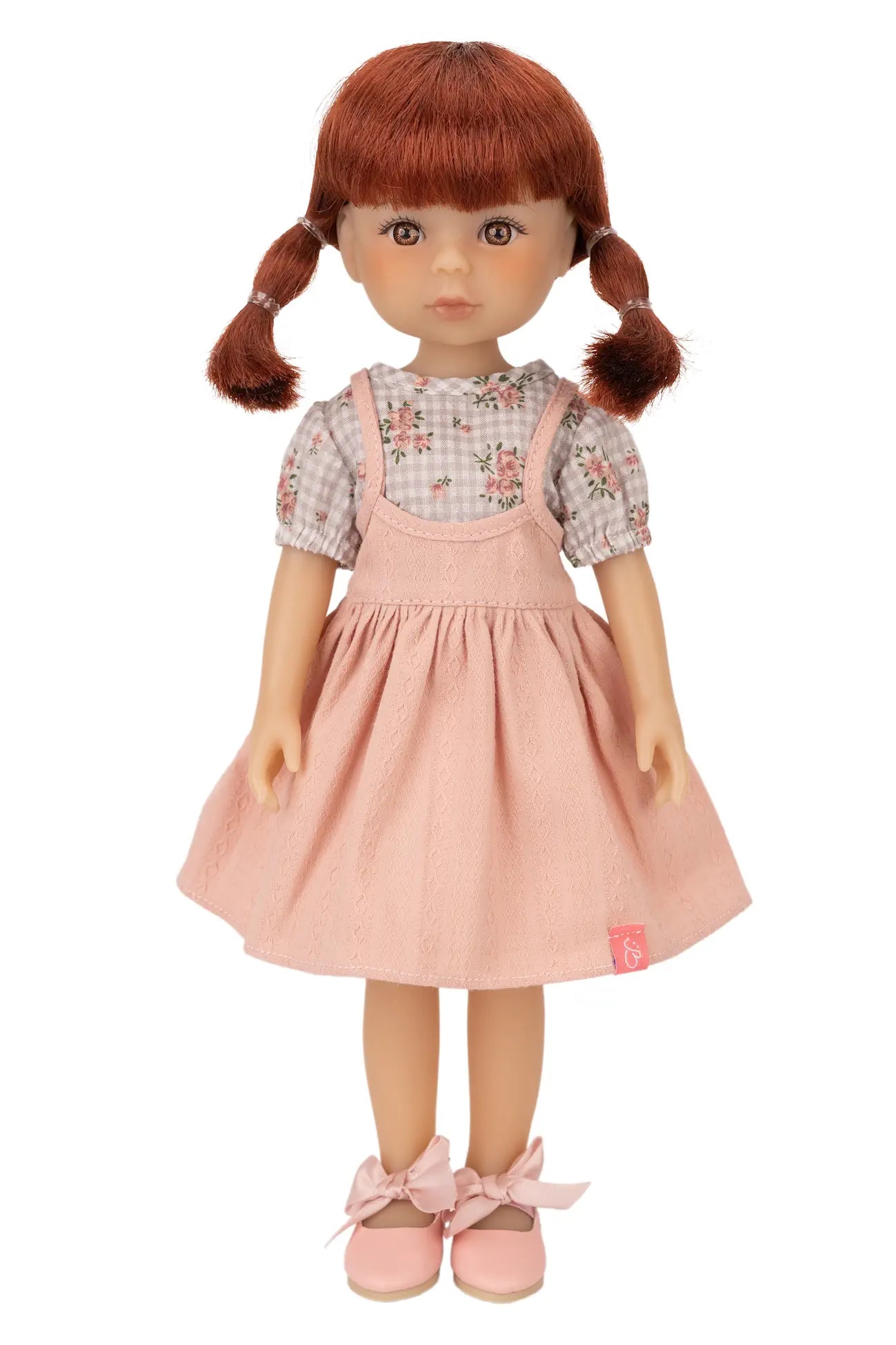 Jolli Buddies Dorothy Doll with red hair styled in pigtails, wearing a floral top and pink dress on a white background.