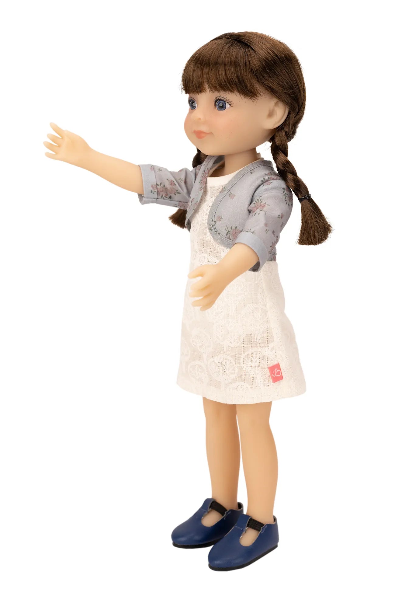 Jolli Buddies Iris Doll with braided hair wearing a gray cardigan, white dress, and blue shoes on a white background