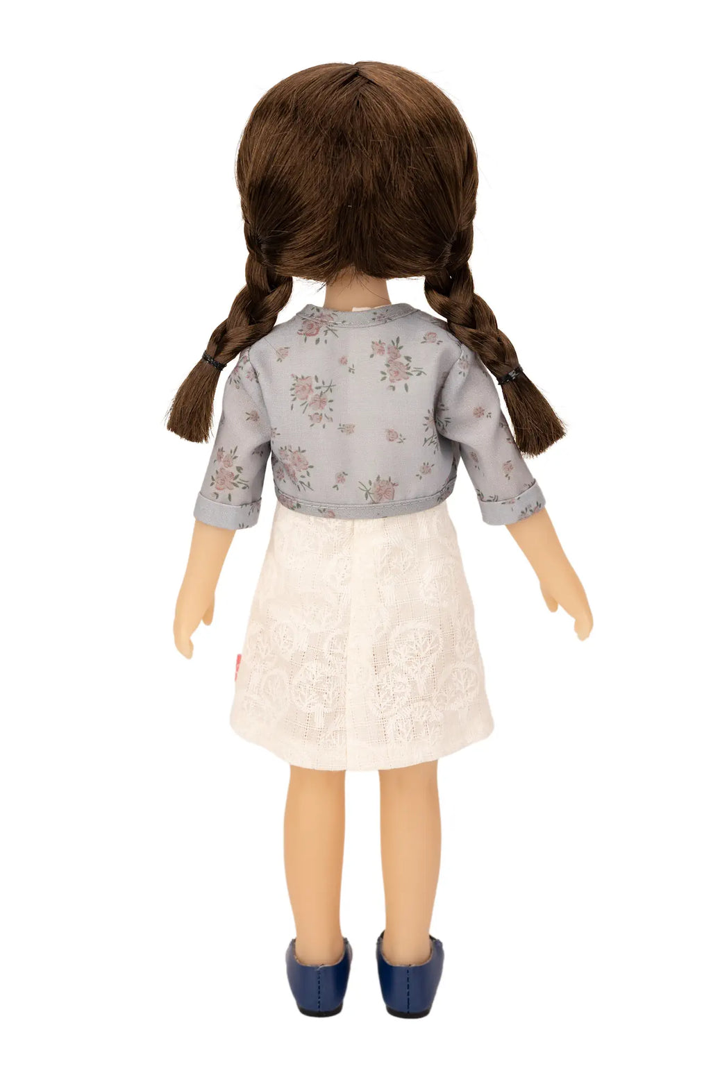 Jolli Buddies Iris Doll wearing a gray floral top and white skirt on a white background