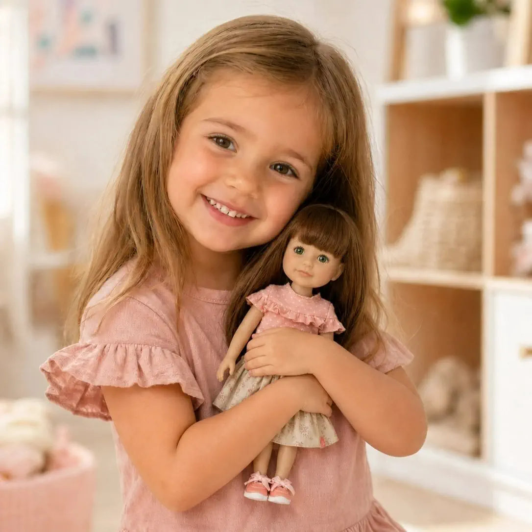 Lillte girl holding a Jolli Buddies doll in a softly lit room