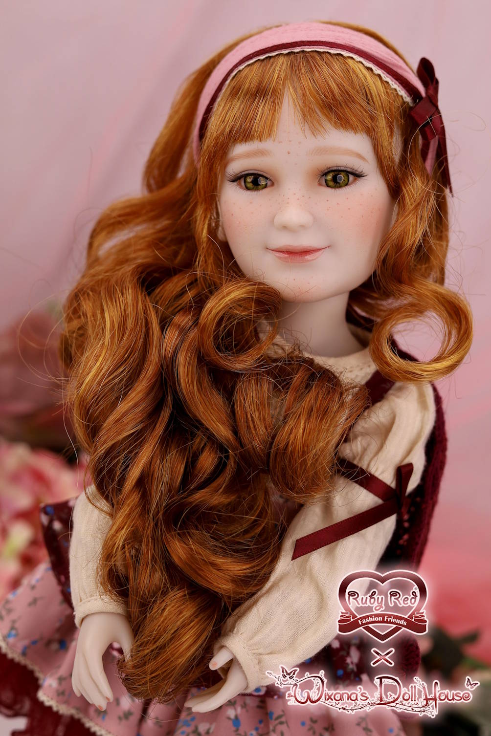Doll with long red hair and a pink headband on a pink background