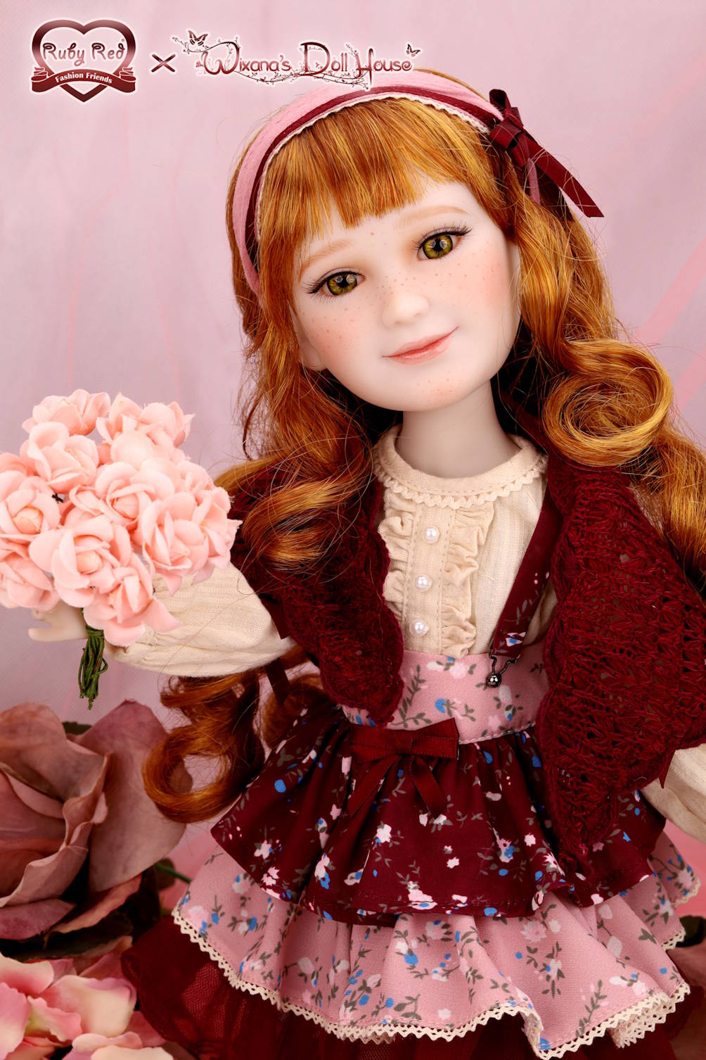 Doll with red hair and a maroon outfit holding pink flowers against a pink background