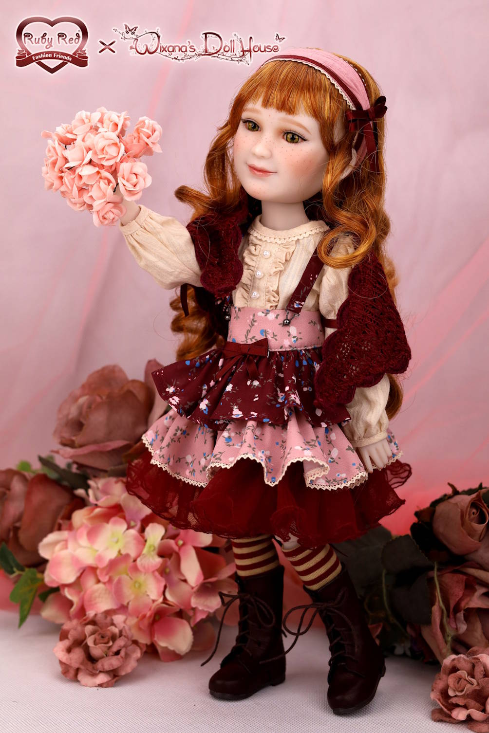 Doll with red hair and a vintage outfit surrounded by flowers on a pink background