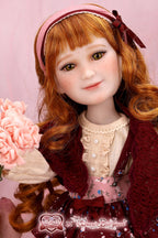 Detailed doll with red hair and a pink headband against a pink background