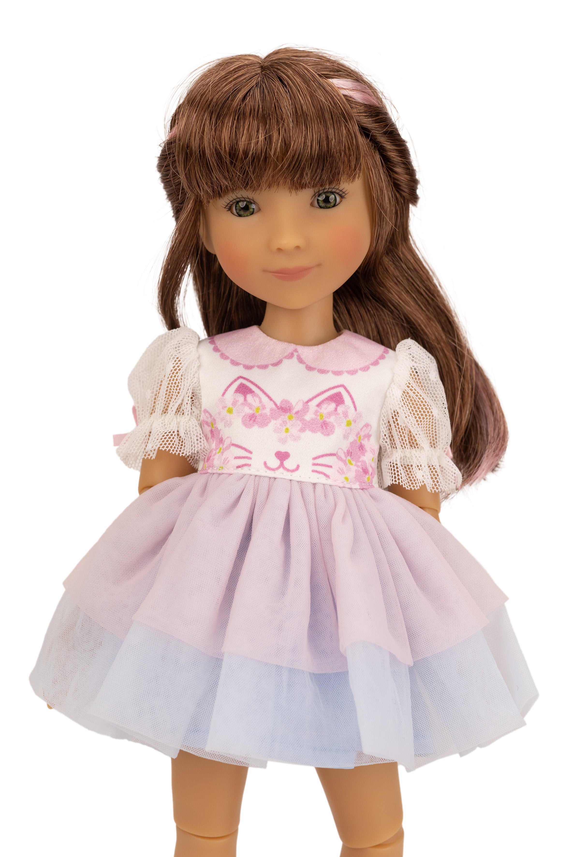 Doll wearing a pink dress with cat design on a white background