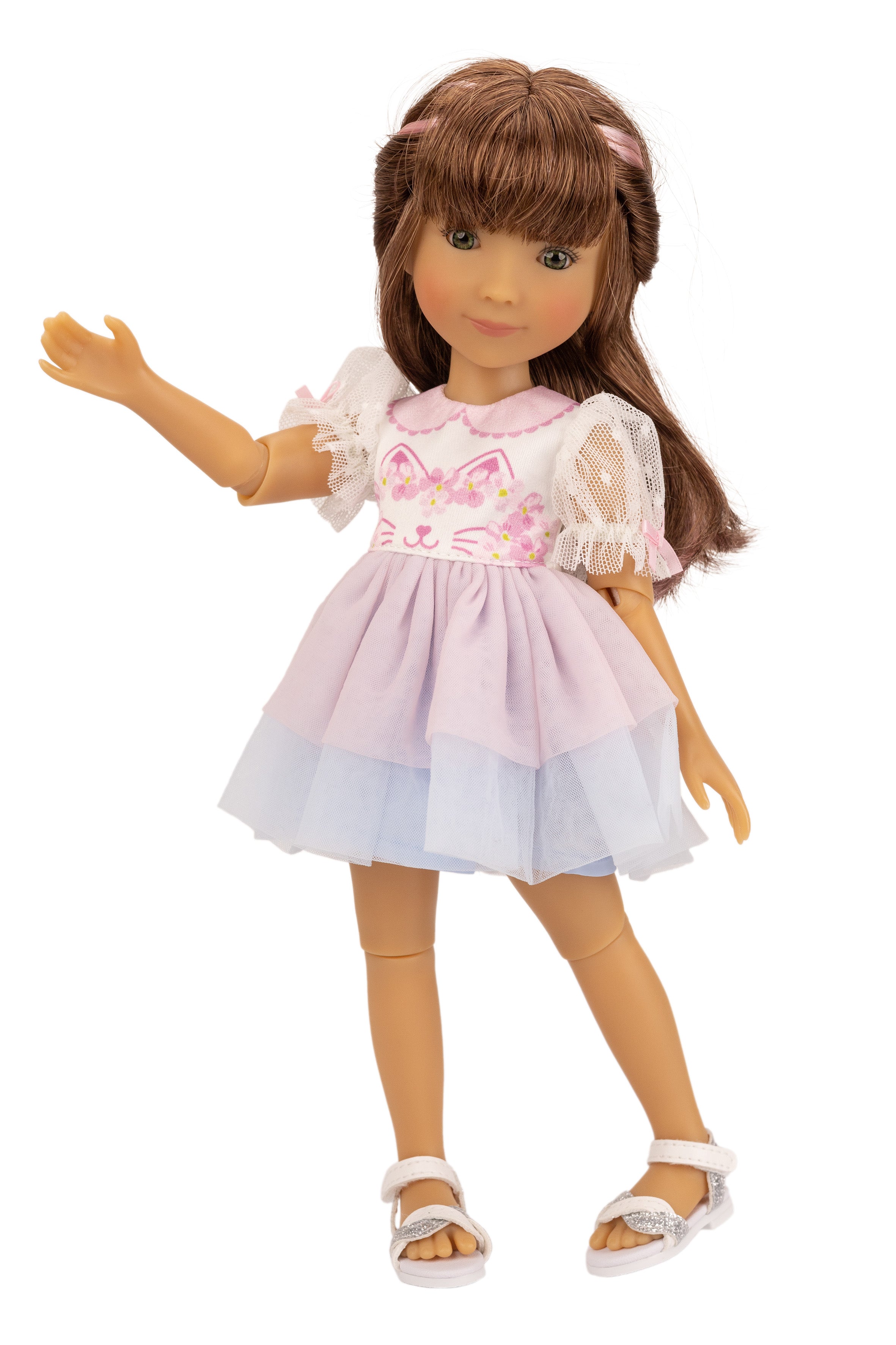 Doll wearing a pink dress with a cat design on a white background