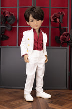 Doll in formal attire against a decorative wall with red and black elements.