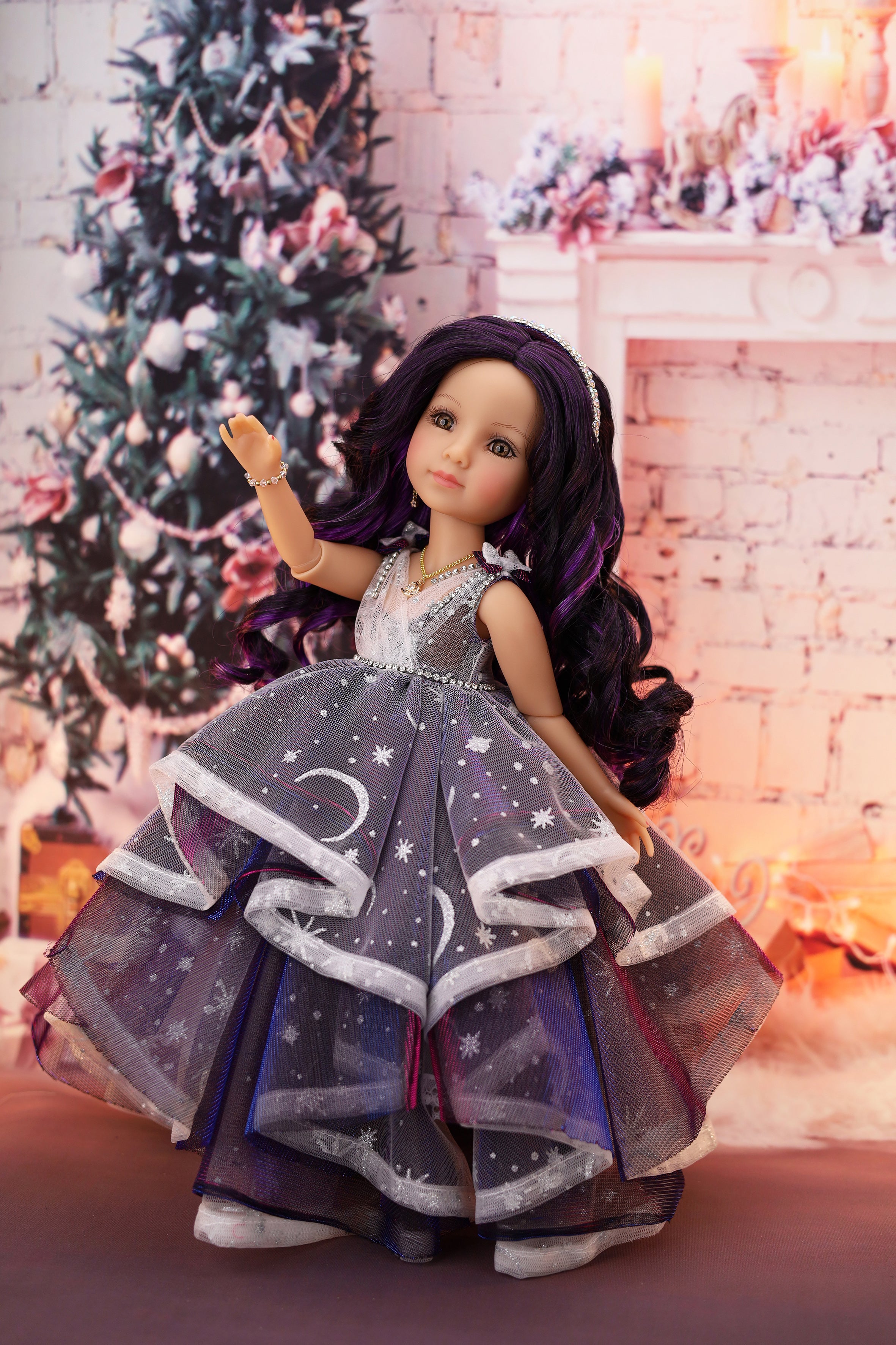 Doll in a festive setting with a decorated Christmas tree and fireplace.