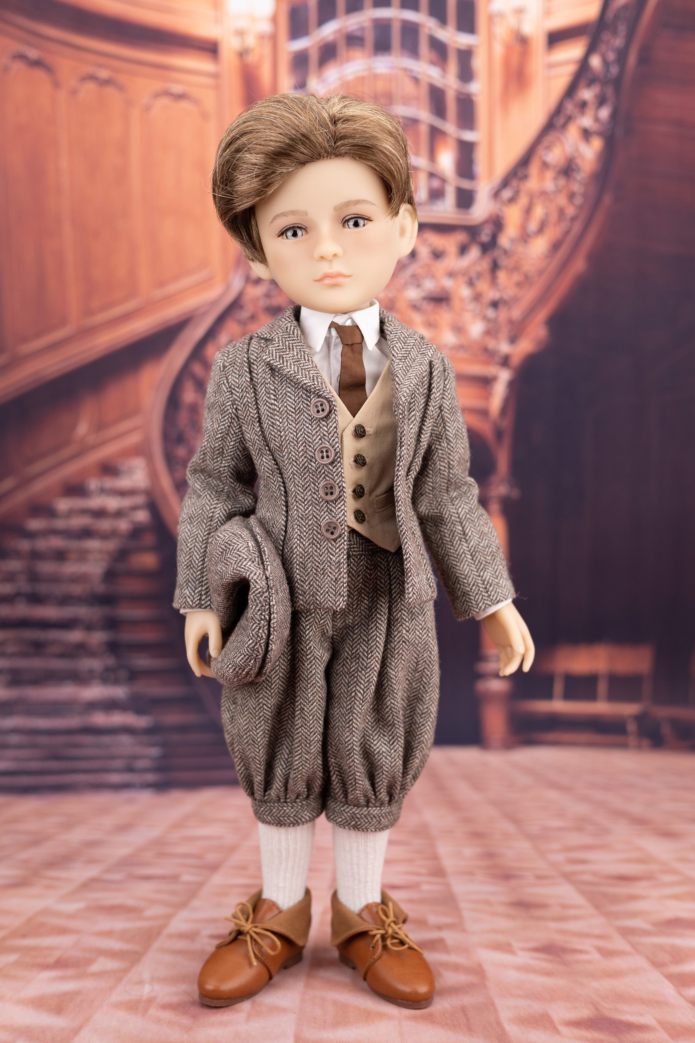 Doll in a formal outfit standing in a room with wooden paneling and a staircase.