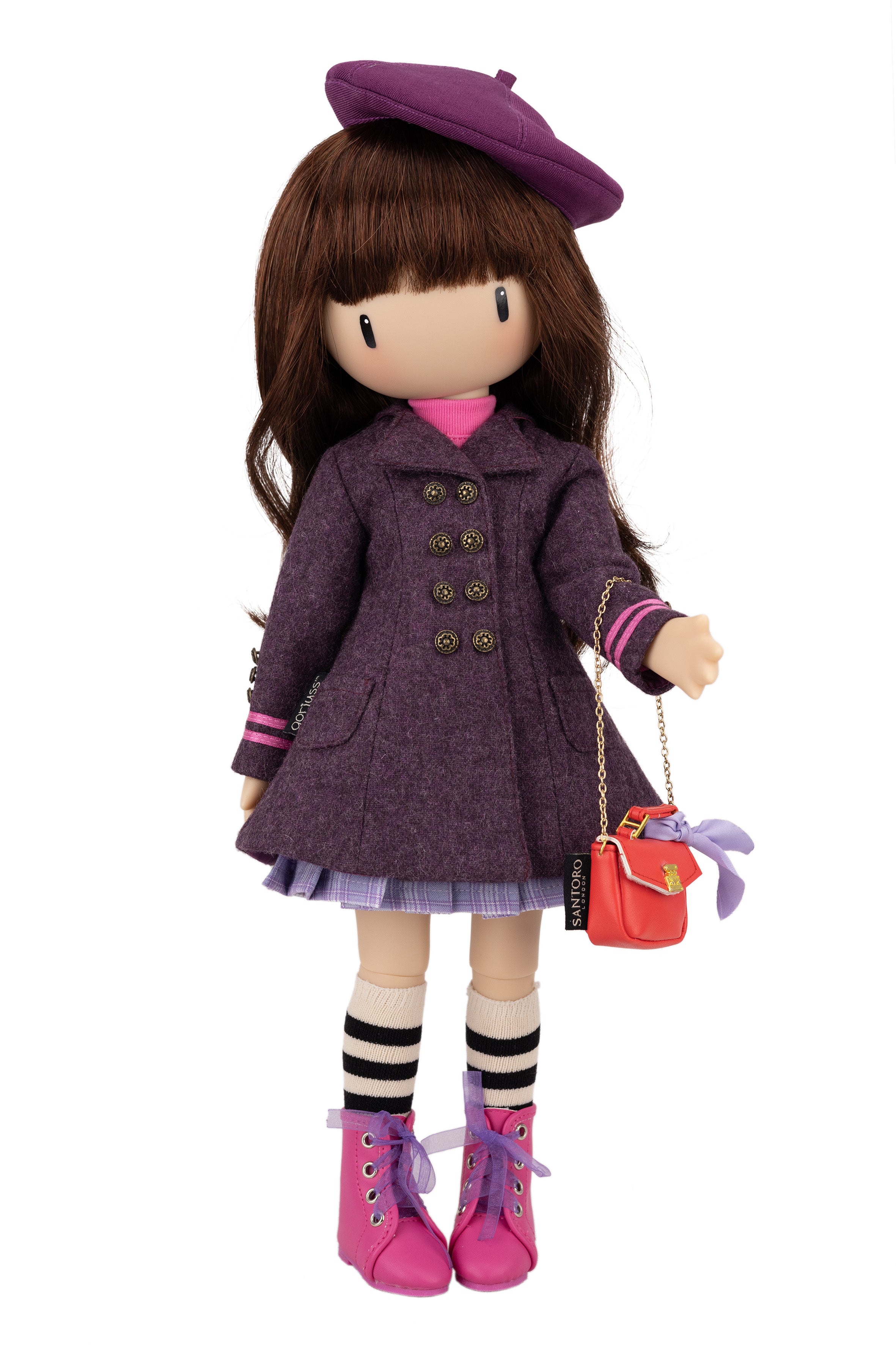 Doll wearing a purple coat, hat, and boots with a red bag on a white background