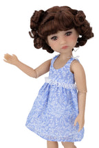 Doll with brown hair wearing a blue floral dress on a white background